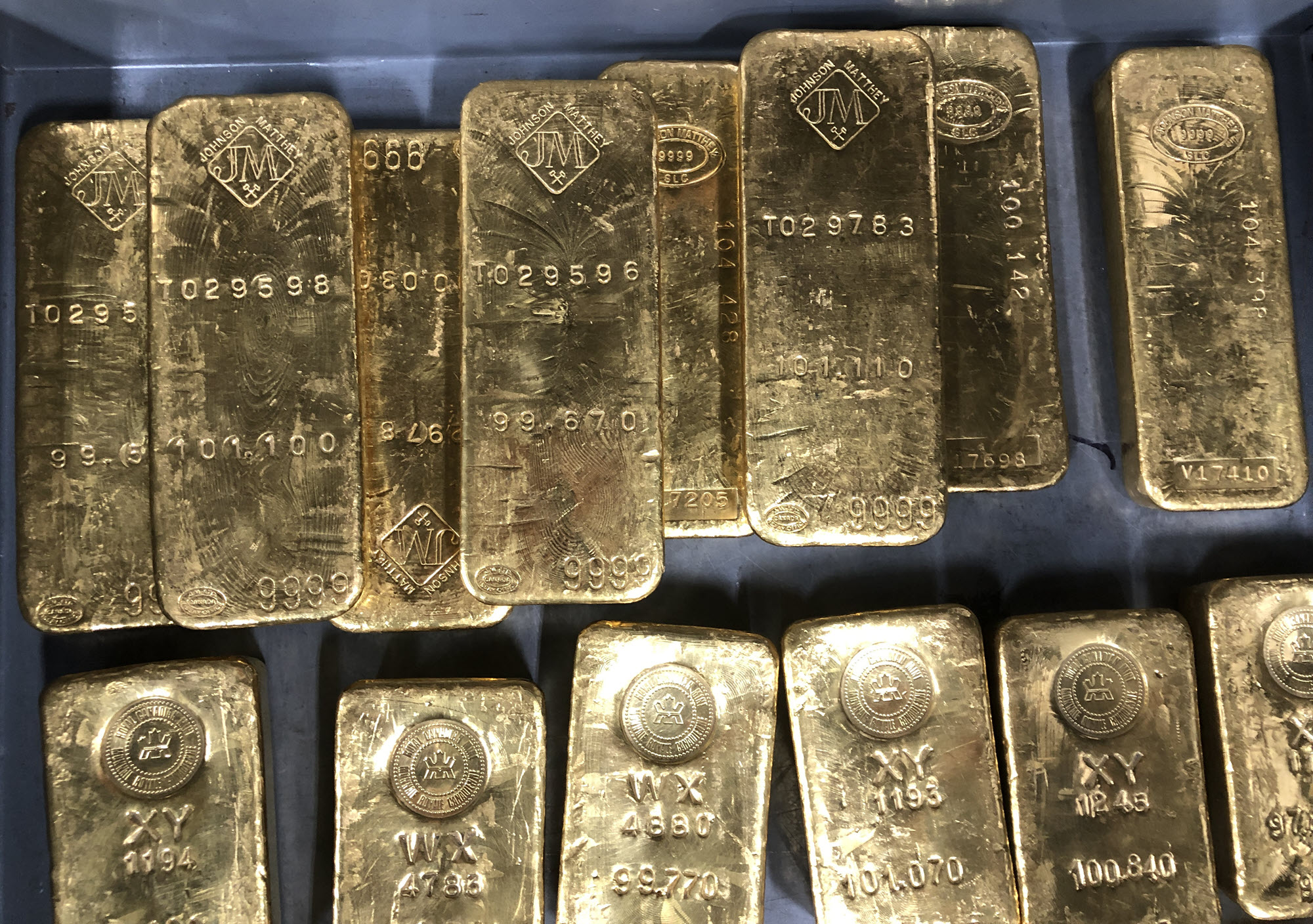 Assorted gold bars on a tray within a vault