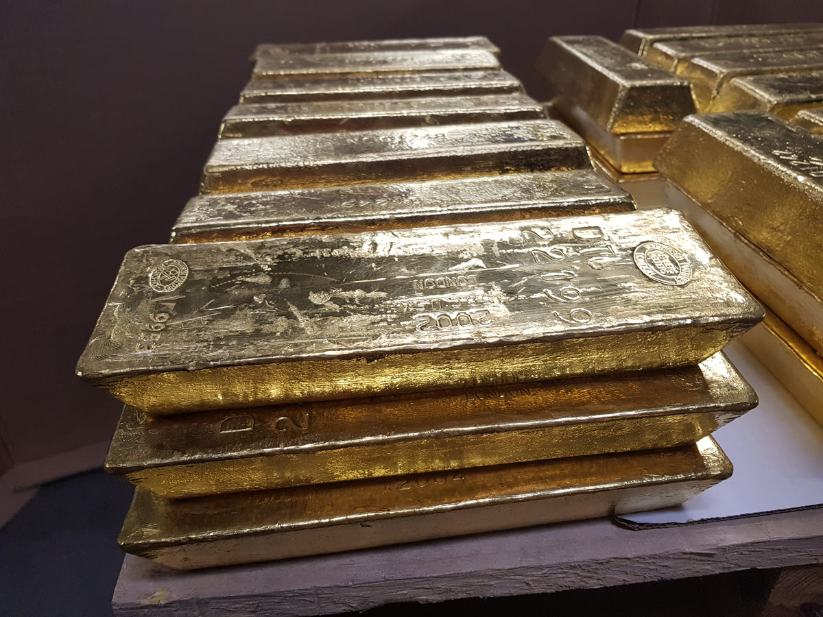 Gold bars stacked 3 high on a pallet in a vault